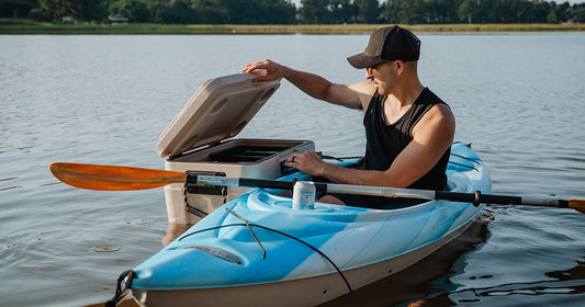 a person in a kayak next to a floating cooler.