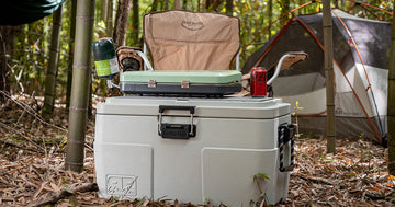 a rugged road cooler with camping accessories on top