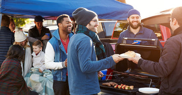 a person cooking over a hot grill at a tailgate party